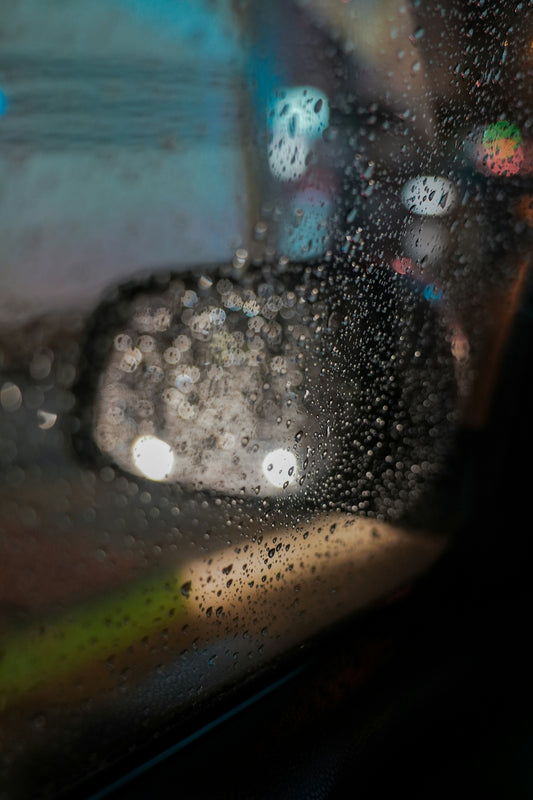 a car's rear view mirror with rain drops on it