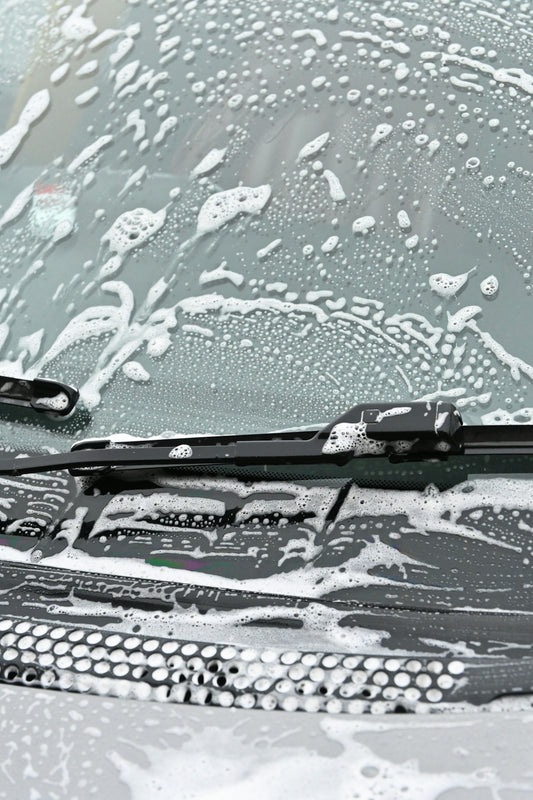 The windshield of a car covered in snow