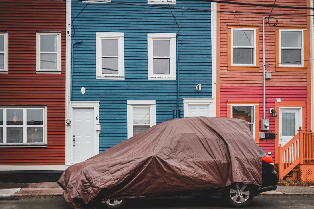 black car parked in front of blue house