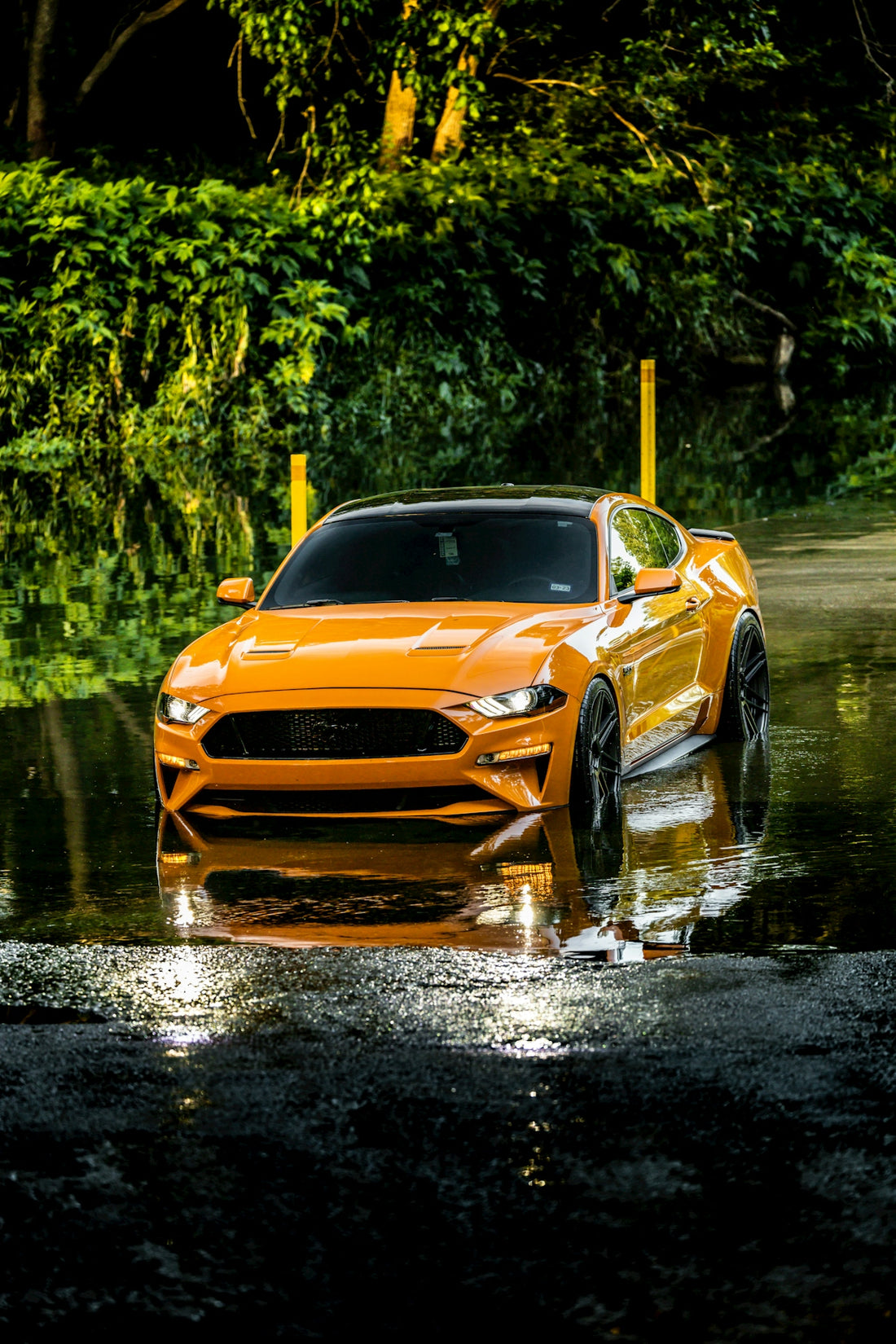 a yellow sports car on a wet road