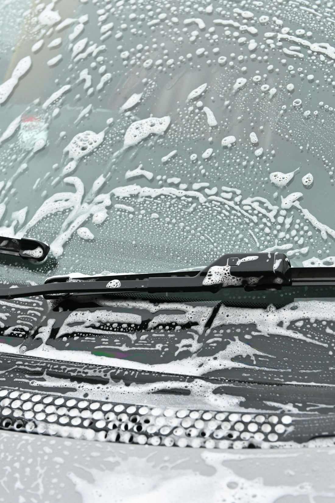 The windshield of a car covered in snow