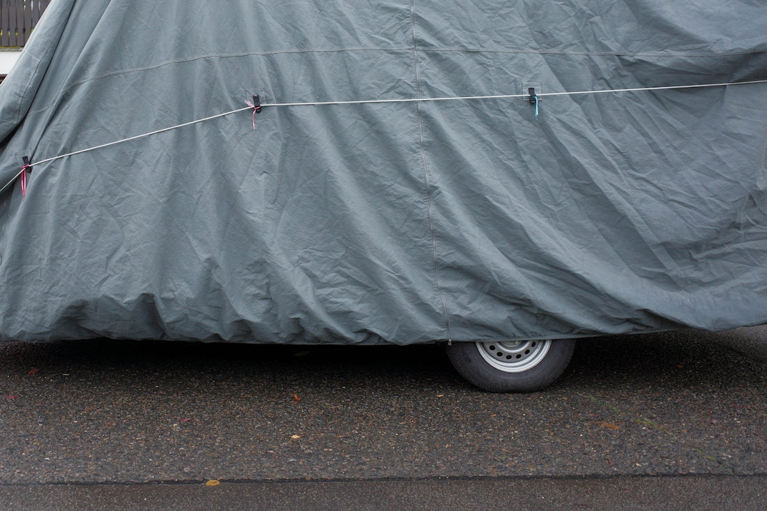 A car covered in a cover on the side of the road