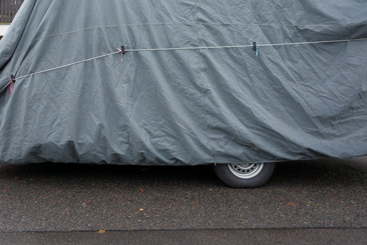 A car covered in a cover on the side of the road